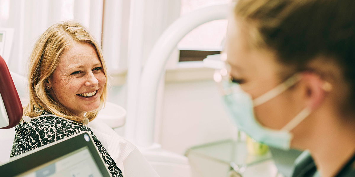 Eine Patientin lächelt Zahnärztin Ricarda Richter an.