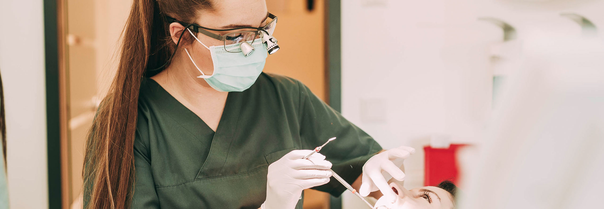 Zahnärztin Ricarda Richter mit Lupenbrille bei der Untersuchung eines Patienten für Veneers.