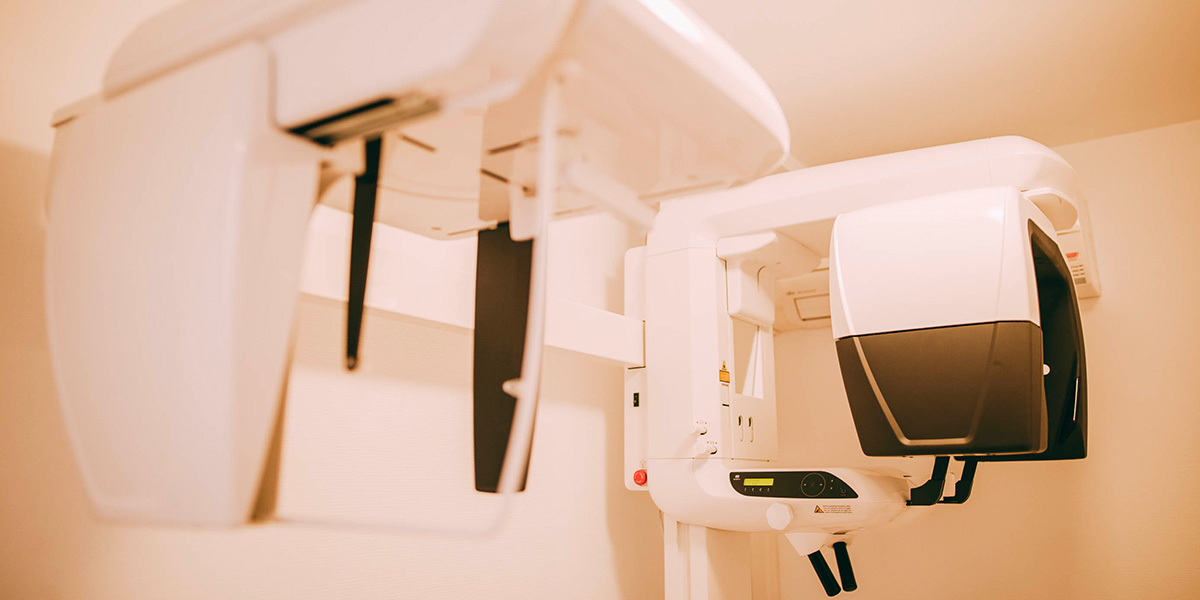 Ein Schrägansicht eines DVT in der Zahnarztpraxis Hanau. Das Gerät sieht sehr futuristisch aus, es besteht aus glatten, weißen und schwarzen Wänden, zwischen denen die Patienten gescannt werden.